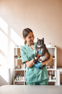 Veterinarian Holding Cat in Arms While Smiling