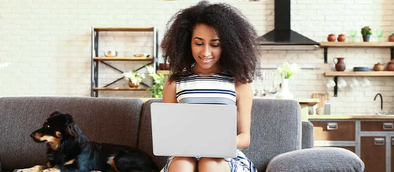 Lady Sitting on Couch Looking at Her Laptop