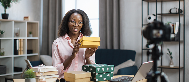 Woman Holding Boxed Gifts While Smiling